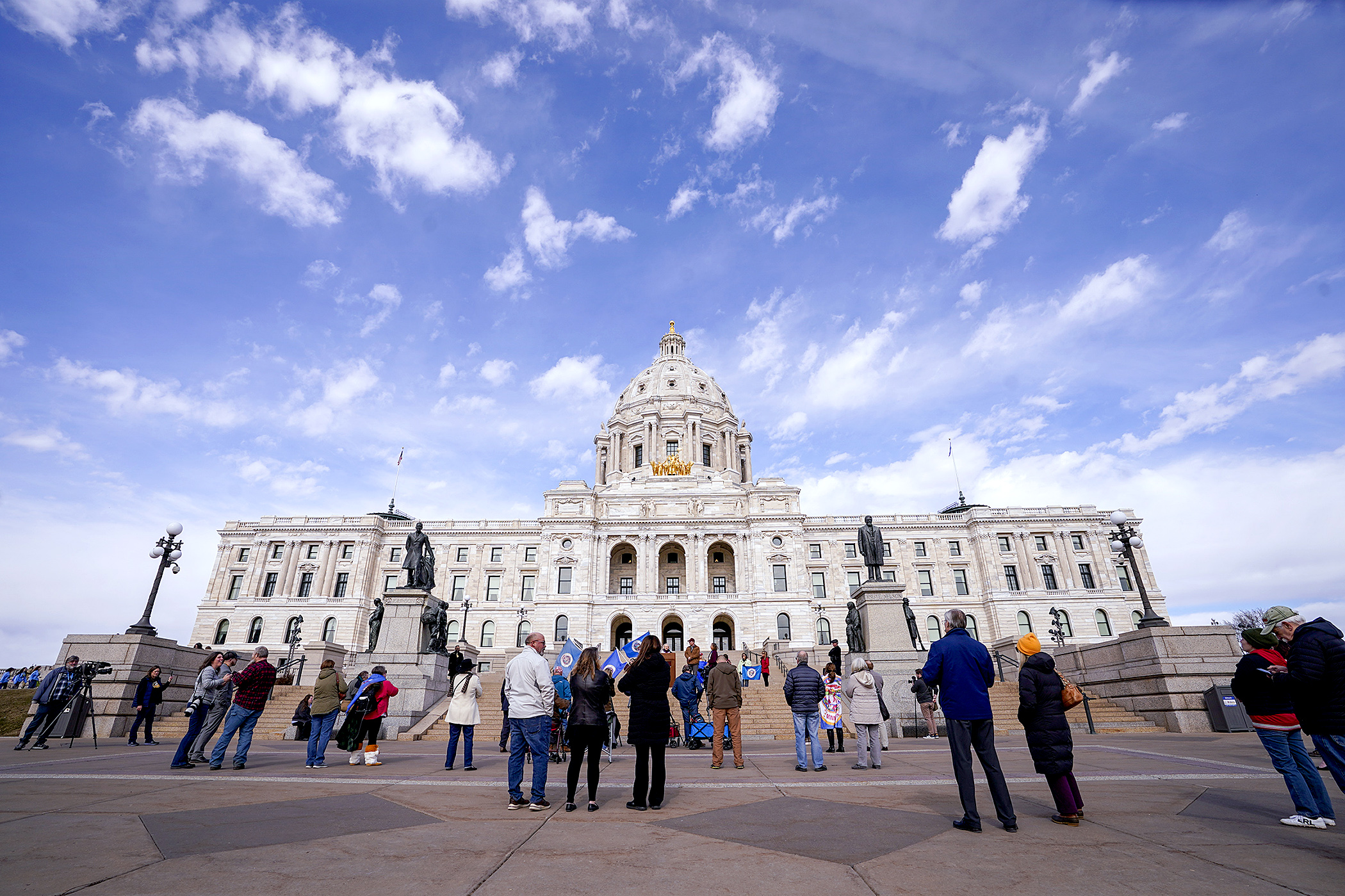 About two dozen people attended the Citizens Voice for the Minnesota Flag rally on the steps of the Capitol March 5 to protest the new state flag. (Photo by Michele Jokinen) 